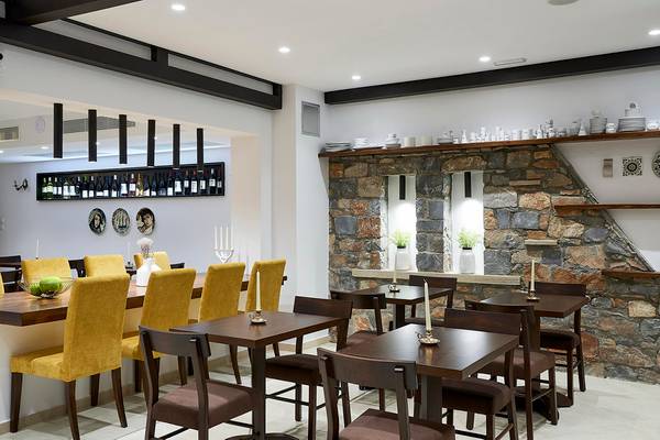 Innenbereich des Albatros Spa & Resort Restaurants mit Steinwand und gerahmten Fenstern.