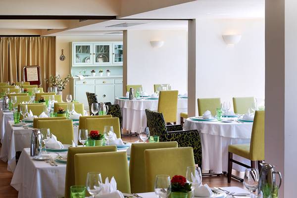 Restaurant im Albatros Spa & Resort mit gedeckten Tischen und Stühlen.