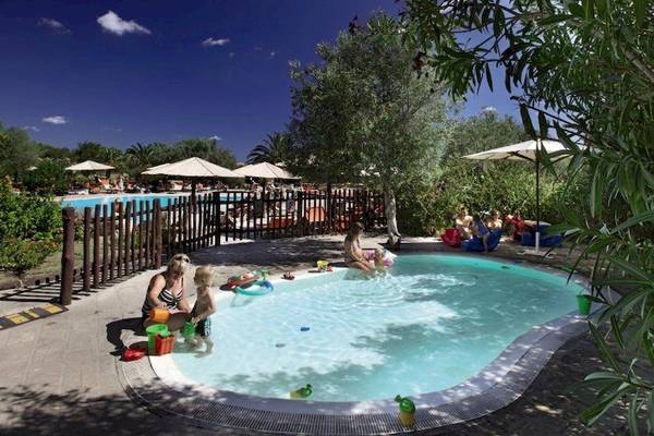 Familie mit Kindern am Kinderbecken im Resort Cala Di Falco.