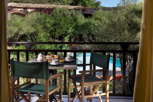 Aussicht von der Terrasse des Resort Cala Di Falco mit Pool und Frühstückstablett.