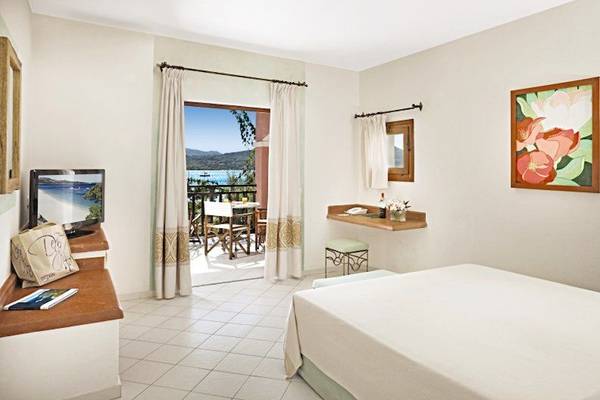 Zimmer im Resort Cala Di Falco mit Blick auf den Balkon und das Meer.