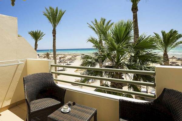 Aussicht von der Balkon des Robinson Djerba Bahiya Hotels auf den Strand und Palmen.