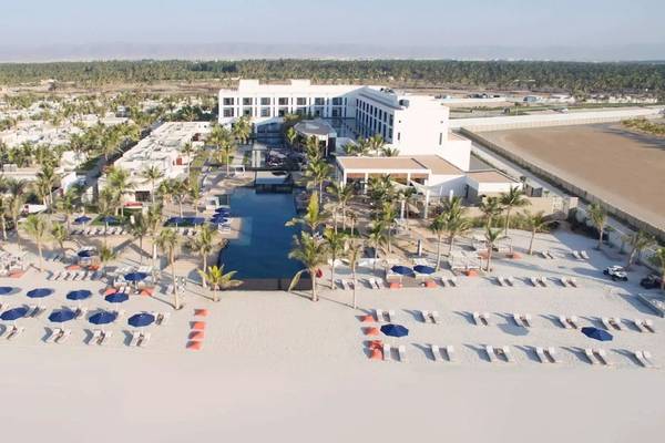 Luftaufnahme des Al Baleed Resorts Salalah von Anantara mit Swimmingpool und vielen Liegen und Sonnenschirmen am Strand