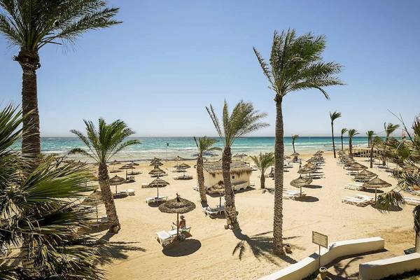 Strandansicht des Robinson Djerba Bahiya Hotels mit Palmen und Sonnenschirmen