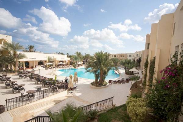 Außenbereich des Green Palm Hotels mit Swimmingpool, Sonnenliegen und Palmen