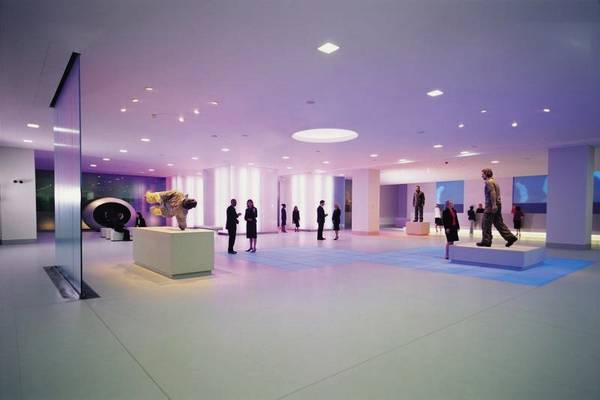 Lobby des Cumberland Hotels mit mehreren Personen und Kunstwerken.