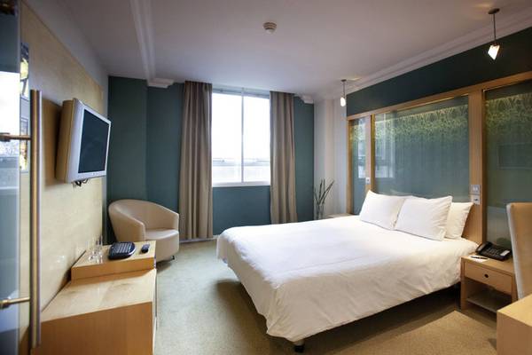 Hotelzimmer im Cumberland mit Bett, Fernseher, Schreibtisch und Stuhl