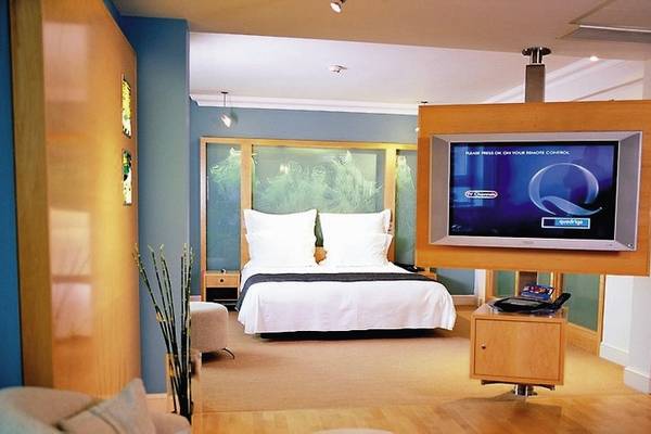Ein Hotelzimmer im Cumberland mit einem Bett, Fernseher, und einem Tisch