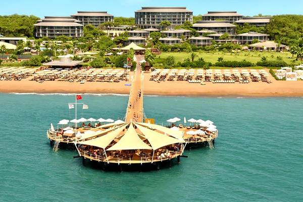 Luftaufnahme des Calista Luxury Resorts mit vielen Gebäuden am Strand und einer großen Lounge auf dem Wasser.