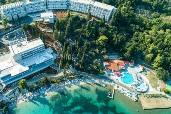 Luftaufnahme des Osmine Slano Hotels, umgeben von Bäumen und mit Blick auf das Meer.
