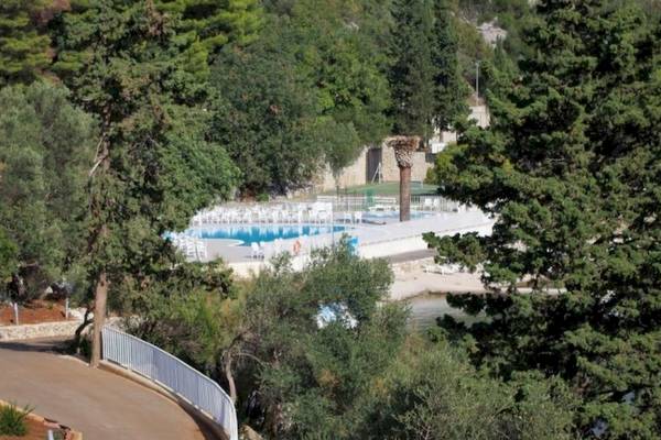 Außenpool des Osmine Slano Hotels umgeben von Bäumen und Wegen