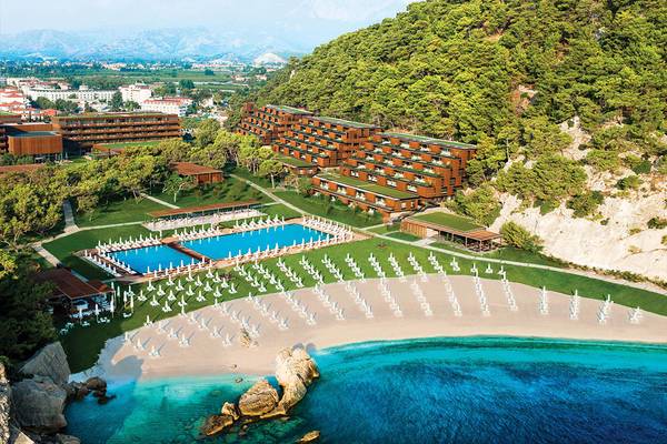 Luftaufnahme des Maxx Royal Kemer Resorts mit Swimmingpools und weißen Liegestühlen am Strand.
