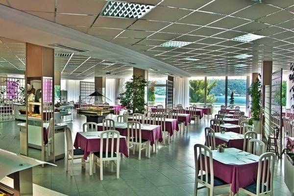 Innenansicht des Restaurants im Osmine Slano Hotel mit runden Tischen, Stühlen und Buffet.