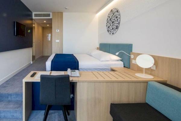 Osmine Slano Hotelzimmer mit Bett, Schreibtisch und Stuhl.