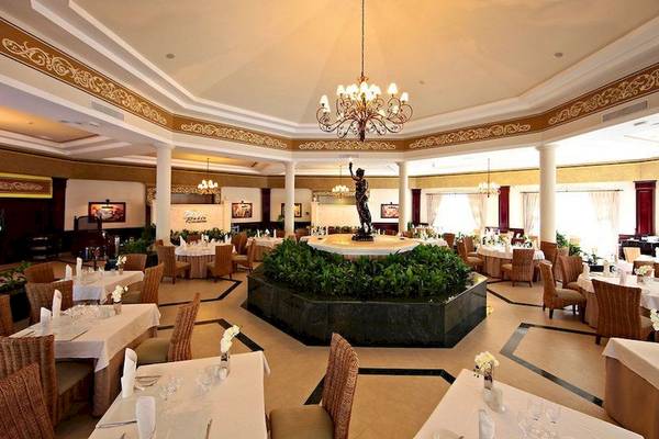 Innenansicht des Restaurants im Bahia Principe Luxury Ambar Hotel mit Tisch und Stuhl-Arrangement.