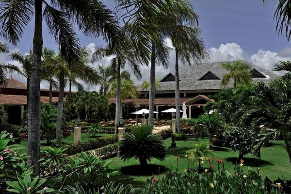 Außenbereich des Bahia Principe Luxury Ambar Hotels mit Palmen und Gebäuden.