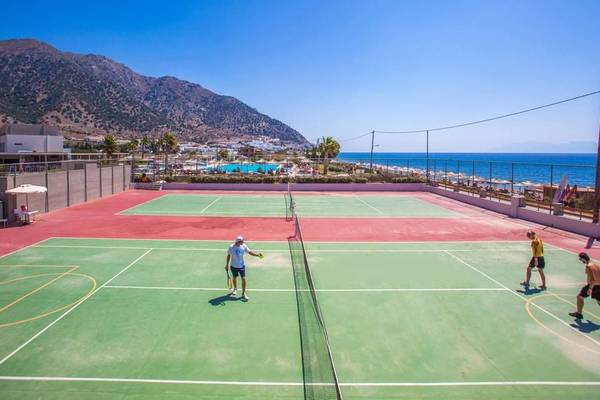 Tennisplätze am Strand des Akti Palace Hotels mit Spielern und Blick auf das Meer.