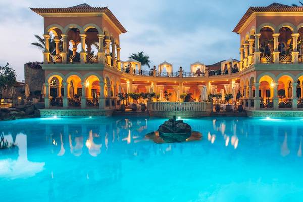 Außenansicht des Iberostar Grand El Mirador Hotels mit beleuchtetem Poolgebäude