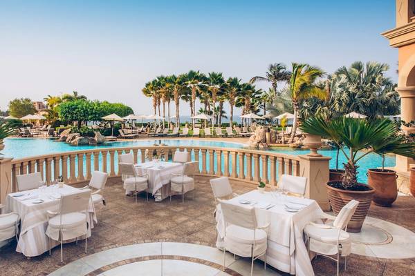 Außenterrasse des Iberostar Grand El Mirador mit Tischen, Stühlen und Blick auf den Pool.