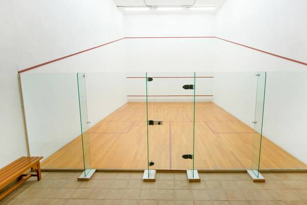Innenansicht des Squash-Courts im Iberostar Grand El Mirador Hotel mit Glaswänden und hölzernem Boden.