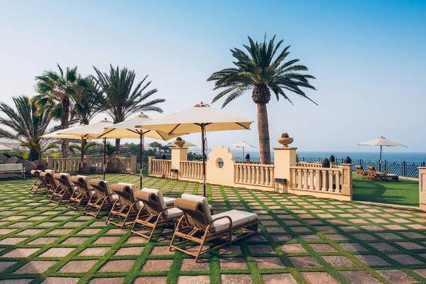 Terrasse des Iberostar Grand El Mirador mit mehreren Liegen, Sonnenschirmen und Blick auf den Ozean