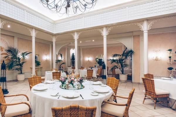 Elegantes Esszimmer im Iberostar Grand El Mirador mit Tisch, Stühlen und Pflanzen.