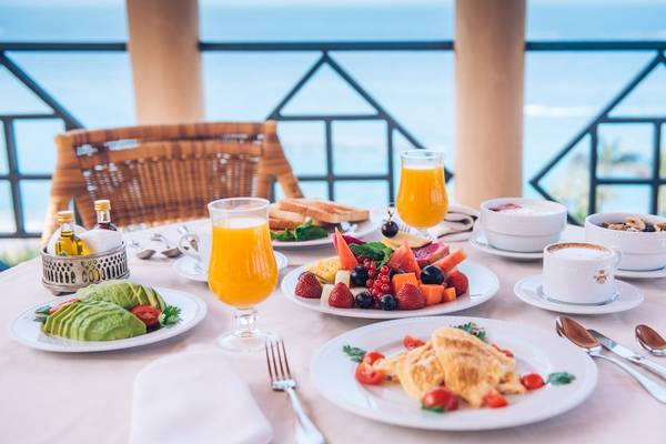 Frühstück auf dem Balkon im Iberostar Grand El Mirador mit Meeresblick, Früchten, Eiern und Getränken.