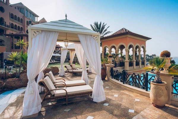 Gazebo mit weißen Vorhängen neben dem Pool des Iberostar Grand El Mirador Hotels.