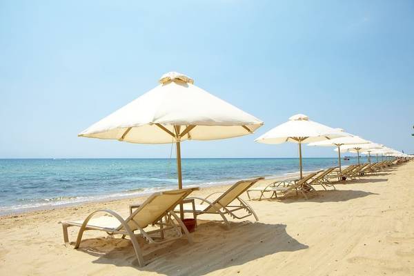 Strand mit Sonnenliegen und Umbrellas im Ikos Oceania