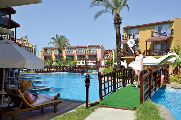 Frau im weißen Kleid neben einem Pool im Selectum Family Resort Side.