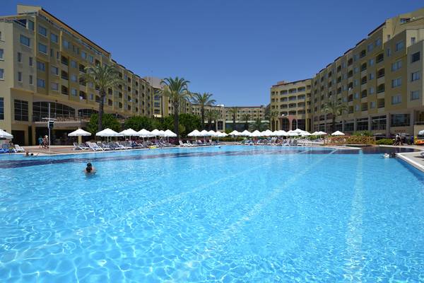 Schwimmbad im Selectum Family Resort Side mit vielen Liegestühlen und Sonnenschirmen.