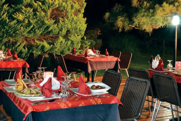 Außenbereich für Abendessen im Selectum Family Resort Side, mit mehreren gedeckten Tischen und rotem Tischtuch.