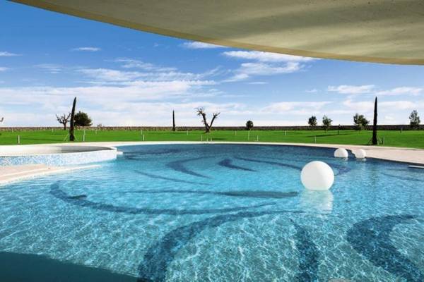 Pool im MIRA Acaya Golf Resort & SPA mit blauem Wasser und weißen Kugeln.