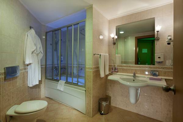 Badezimmer im Selectum Family Resort Side mit Badewanne, Dusche, Toilette und Waschbecken.