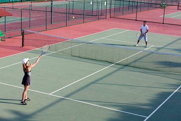 Tennisplatz im Selectum Family Resort Side mit einer Frau und einem Mann, die Tennis spielen.