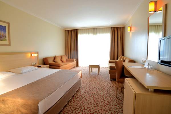 Hotelzimmer im Selectum Family Resort Side mit Doppelbett, Sofa, Schreibtisch und Fernseher.
