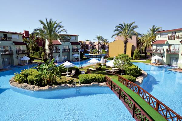Gesamtansicht des Selectum Family Resort Side mit großem Swimmingpool, Brücke und grünen Pflanzen.