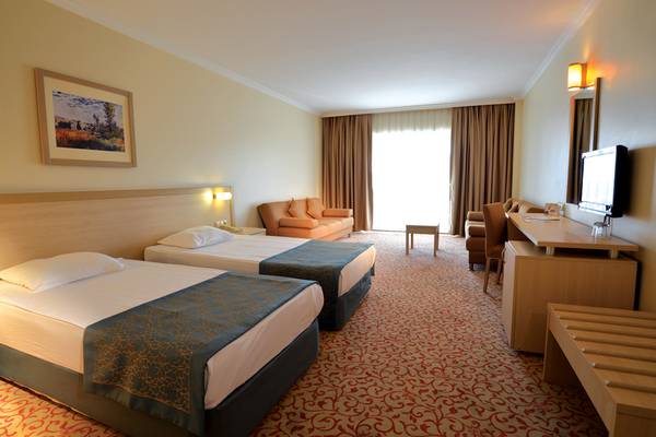 Hotelzimmer mit zwei Betten, Sofa und Schreibtisch im Selectum Family Resort Side.