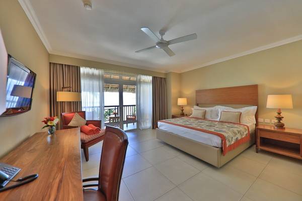 Hotelzimmer im Sands Suites Resort & Spa mit Balkon, Fernseher, Schreibtisch und bequemem Bett.