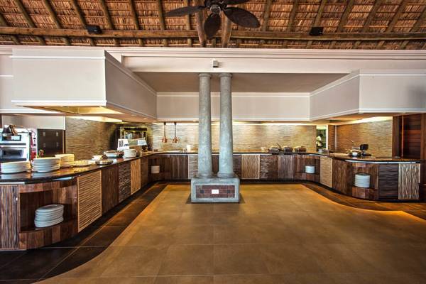 Innenbereich der Küche im Sands Suites Resort & Spa mit Holzmöbeln und Betonsäulen.