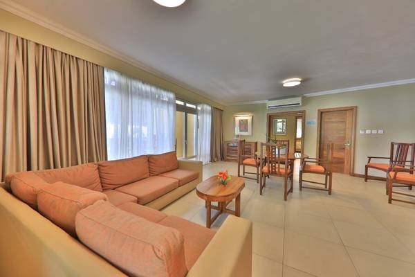 Wohnzimmer im Sands Suites Resort & Spa mit zwei Sofas, einem Tisch, Stühlen und einer Pflanze.