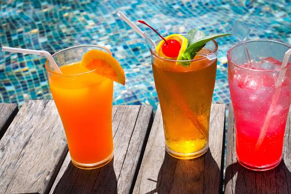 Drei farbige Cocktails auf einem Tisch neben einem Swimmingpool im Crystal Admiral Resort.