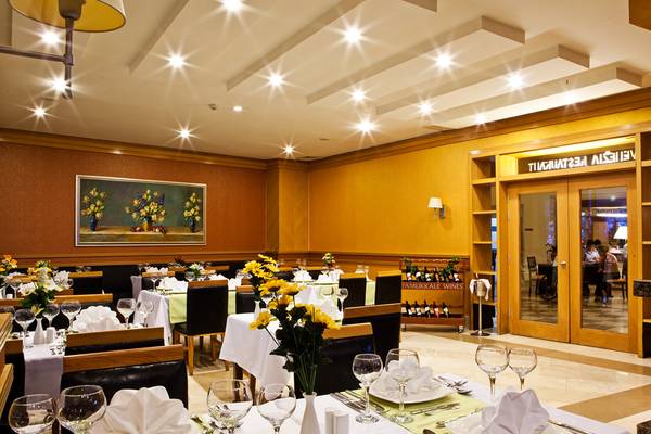 Innenansicht des Restaurants im Crystal Admiral Resort Suites & Spa mit gedeckten Tischen und Stühlen.