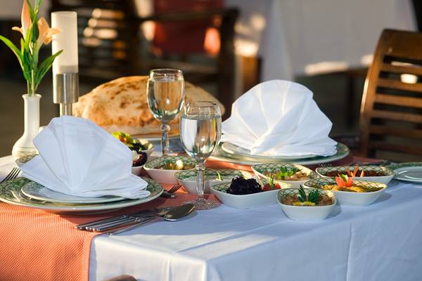 Ein gedeckter Tisch im Crystal Admiral Resort Suites & Spa mit Tellern, Gläsern und Speisen.