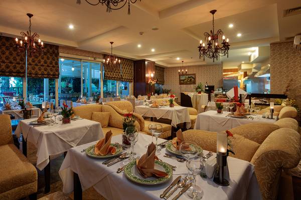 Innenansicht des Restaurants im Crystal Admiral Resort Suites & Spa mit gedeckten Tischen und eleganter Einrichtung.