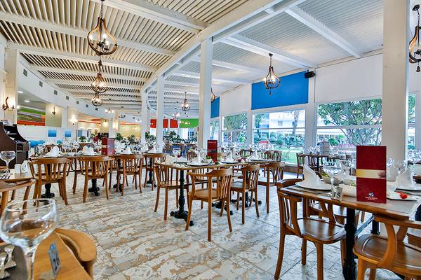 Innenansicht des Restaurants im Crystal Admiral Resort Suites & Spa mit gedeckten Tischen und Stühlen.