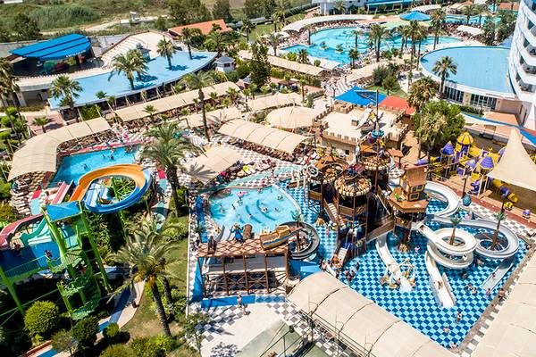 Luftaufnahme des Crystal Admiral Resort Suites & Spa mit mehreren Pools, Wasserrutschen und einem Hotelgebäude im Hintergrund.