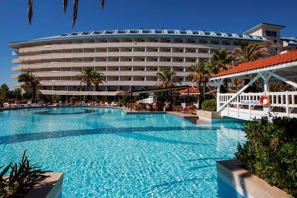 Außenpool des Crystal Admiral Resort Suites & Spa Hotels mit Loungebereich und Sonnenschirmen.