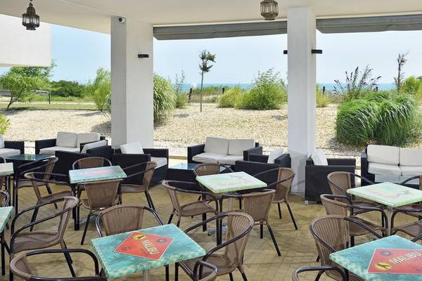 Außenbereich des Sol Luna Bay All Inclusive Hotels mit Tischen, Stühlen und Meerblick