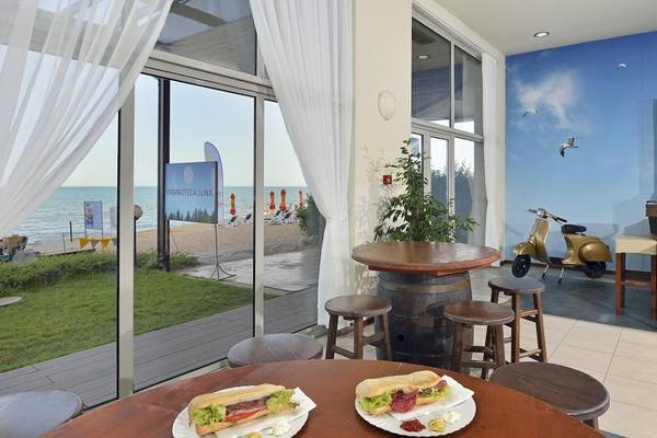 Innenansicht der Terrasse des Sol Luna Bay All Inclusive Hotels mit Blick auf das Meer und eine Bar.